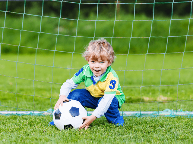 Dieťa s loptou vo futbalovej bráne